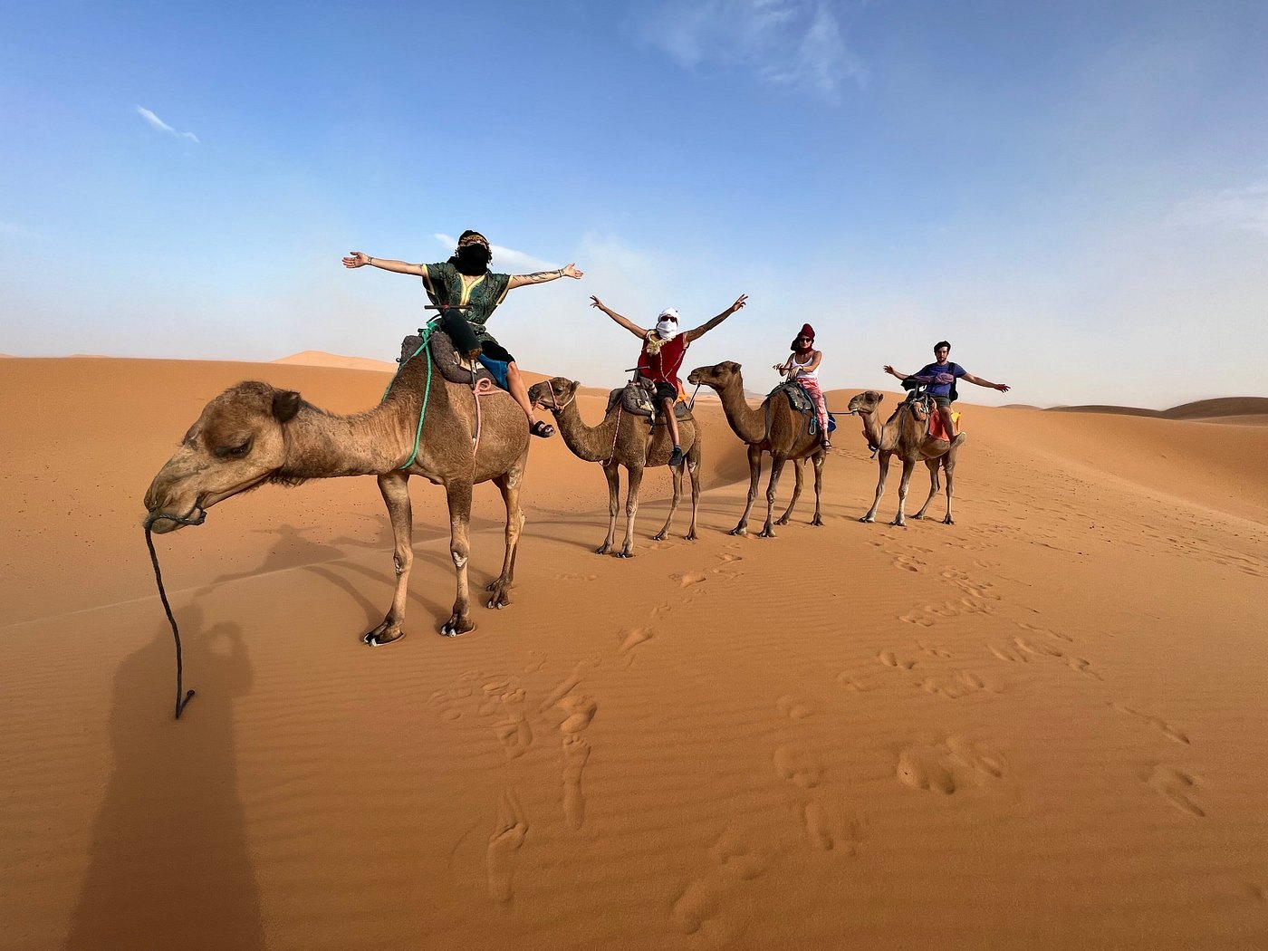 Guests enjoying a playful camel caravan experience in Merzouga