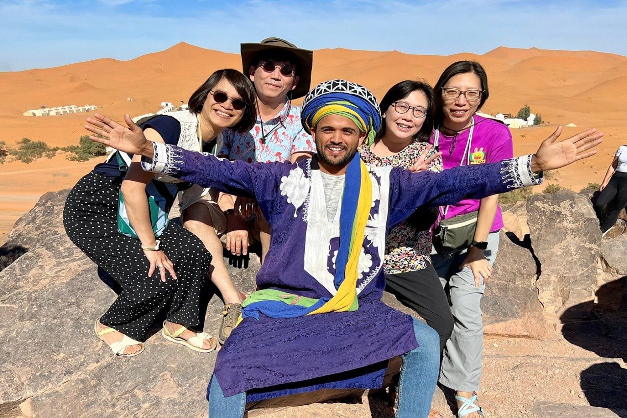 Local Merzouga guide with a group of guests overlooking the dunes