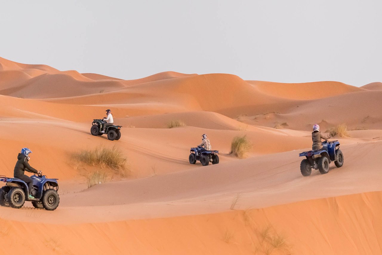 Guests riding quad bikes across the Merzouga dunes